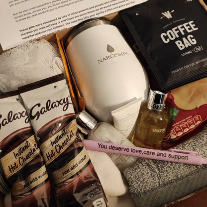 Gourmet gift set with coffee, hot chocolate, and other items in a box.